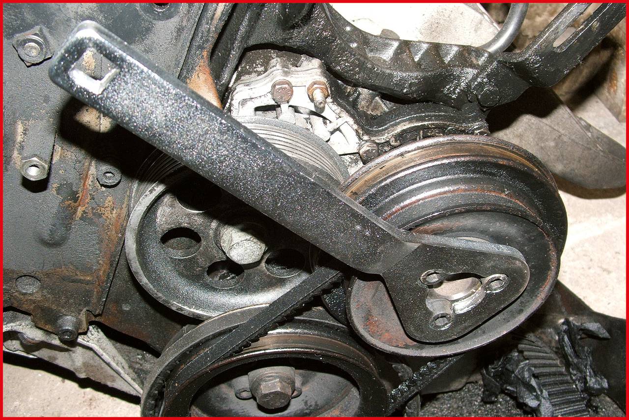 'Motor vehicle with rusted pulleys and an attached spanner used for repair or maintenance.'