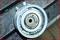 A circular, metallic machine component with a central hole is resting on an industrial surface.