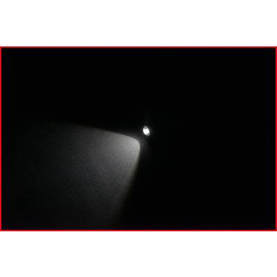 A torch beams a cone of light in a dark room.