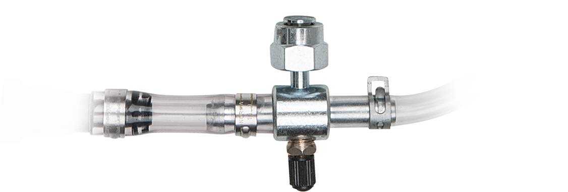 A transparent tube is connected to a metal valve. The valve has a rotary knob to regulate the flow.
