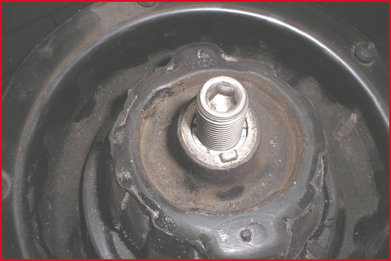 Close-up of a metal screw in a thread, potentially part of a mechanical device or motor.