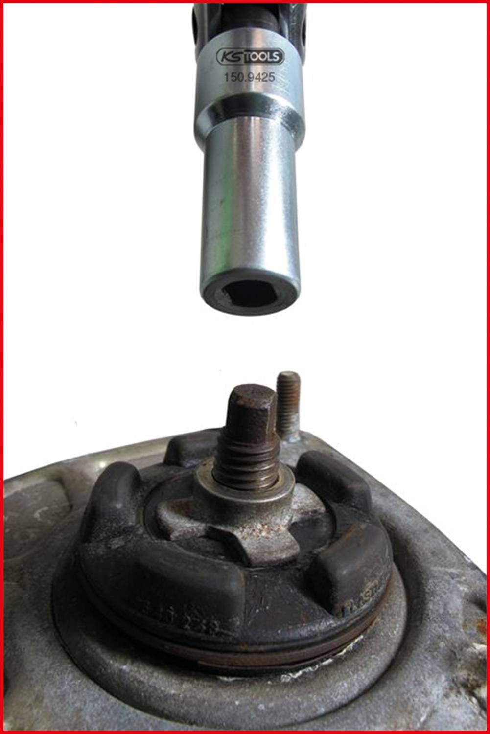 A ratchet is used to loosen a nut on a metal bolt. In the background, other tools are visible.