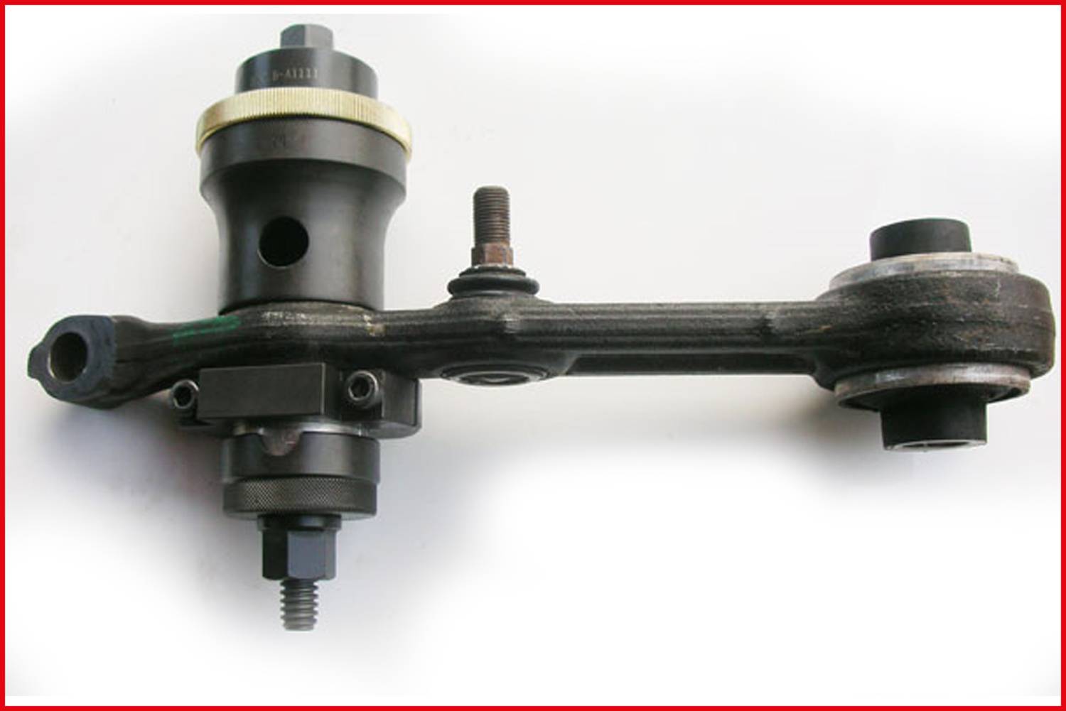 A black metal component with multiple screws and a cylindrical element, likely part of a machinery or vehicle system.