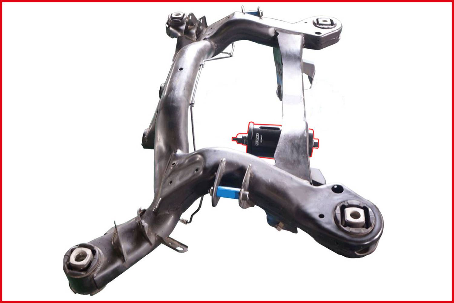 A metal suspension component with multiple arms and mounting points, likely part of a vehicle's chassis.