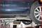 'Car on a lift in a workshop, focus on wheel and undercarriage. Maintenance work is being carried out.'