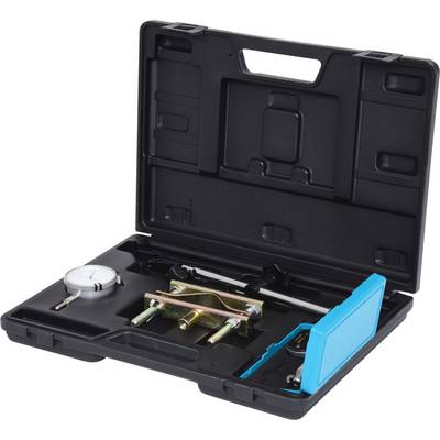 'Open black casing with measuring instruments and metal templates. A dial indicator is visible.'