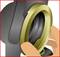 A person's hand turns a gold-coloured ring on a mechanical component. The background is grey.