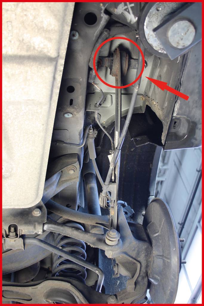 'Image of a vehicle underbody showing a damaged or missing automotive bumper, marked with a red circle and arrow.'