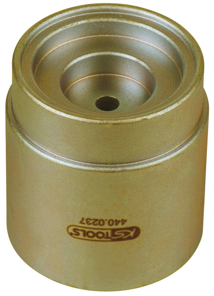 Golden metal cylinder, presumably a tool component. On top are concentric circles and a central hole.