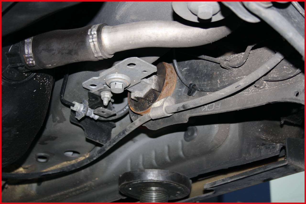 Close-up view of a vehicle's undercarriage, focusing on the exhaust system and adjacent mechanical components.