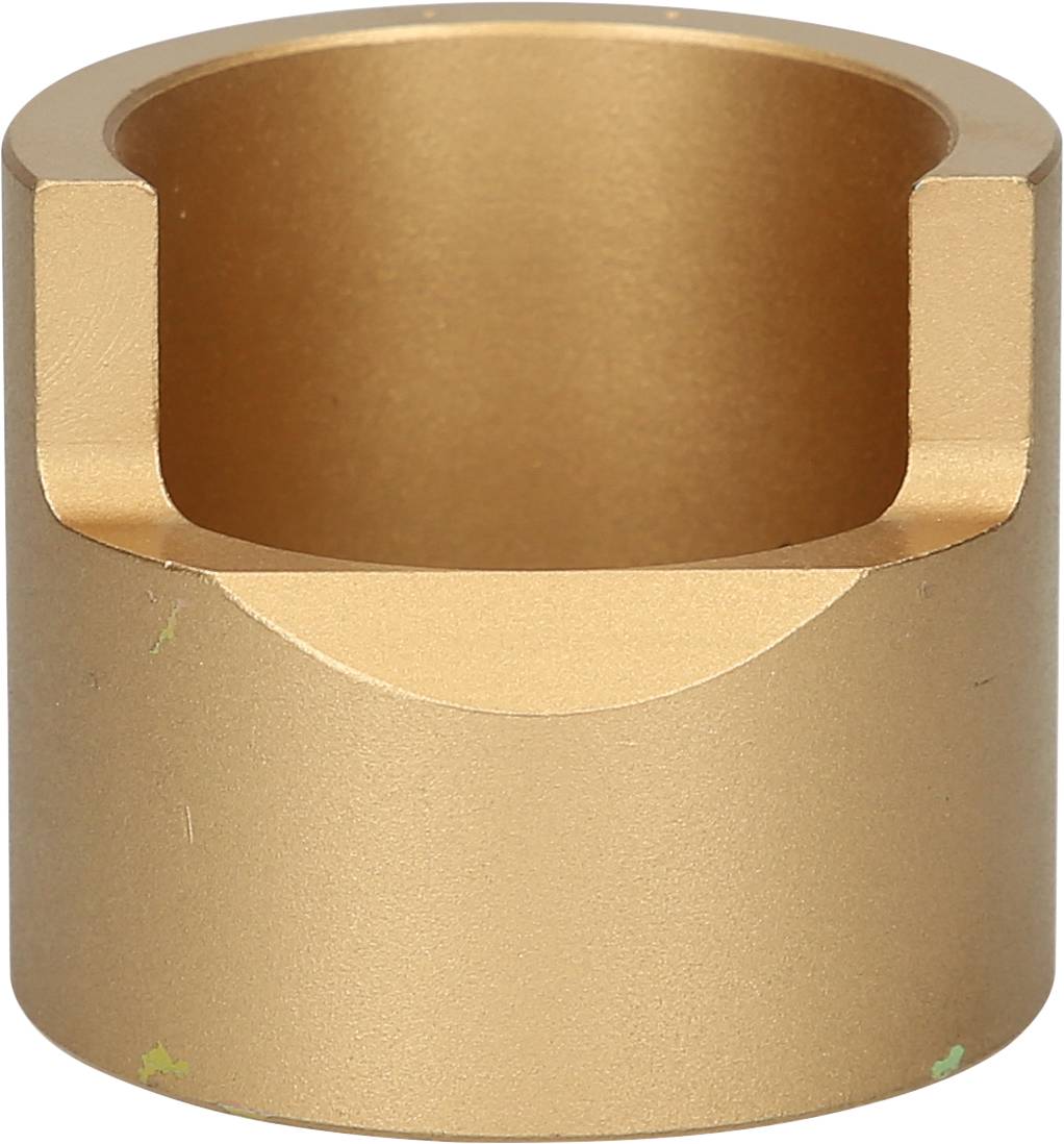 Metallic cylindrical object with a bevelled edge at the top and a smooth, gold-coloured surface.