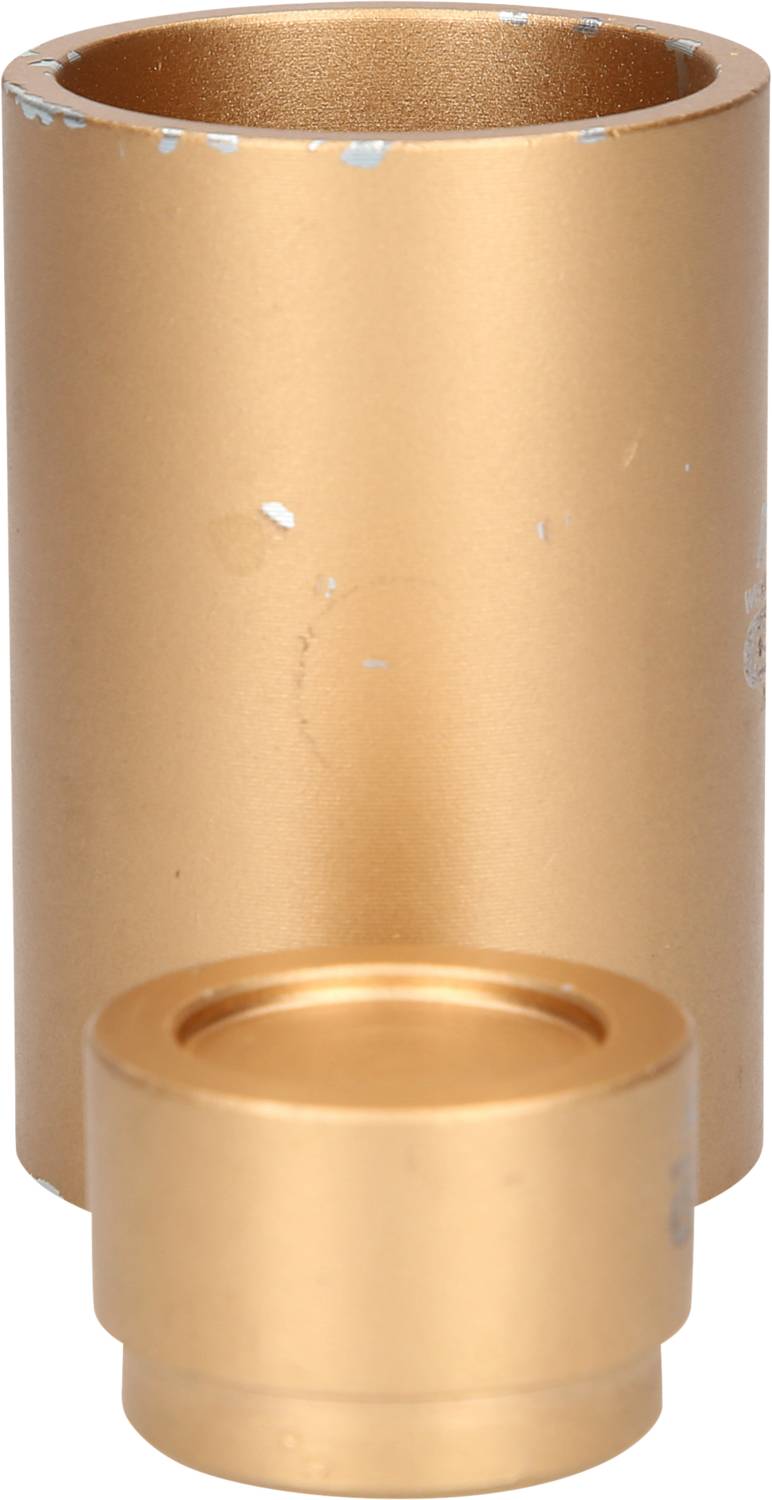 A cylindrical container made of gold-coloured metal, with a smaller, flatter lid beside it. Both parts are worn and scratched.