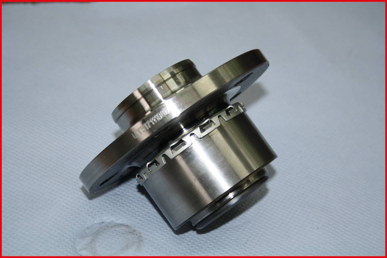 A metal bearing against a grey background, photographed at an angle, reveals precise details and smooth surfaces.