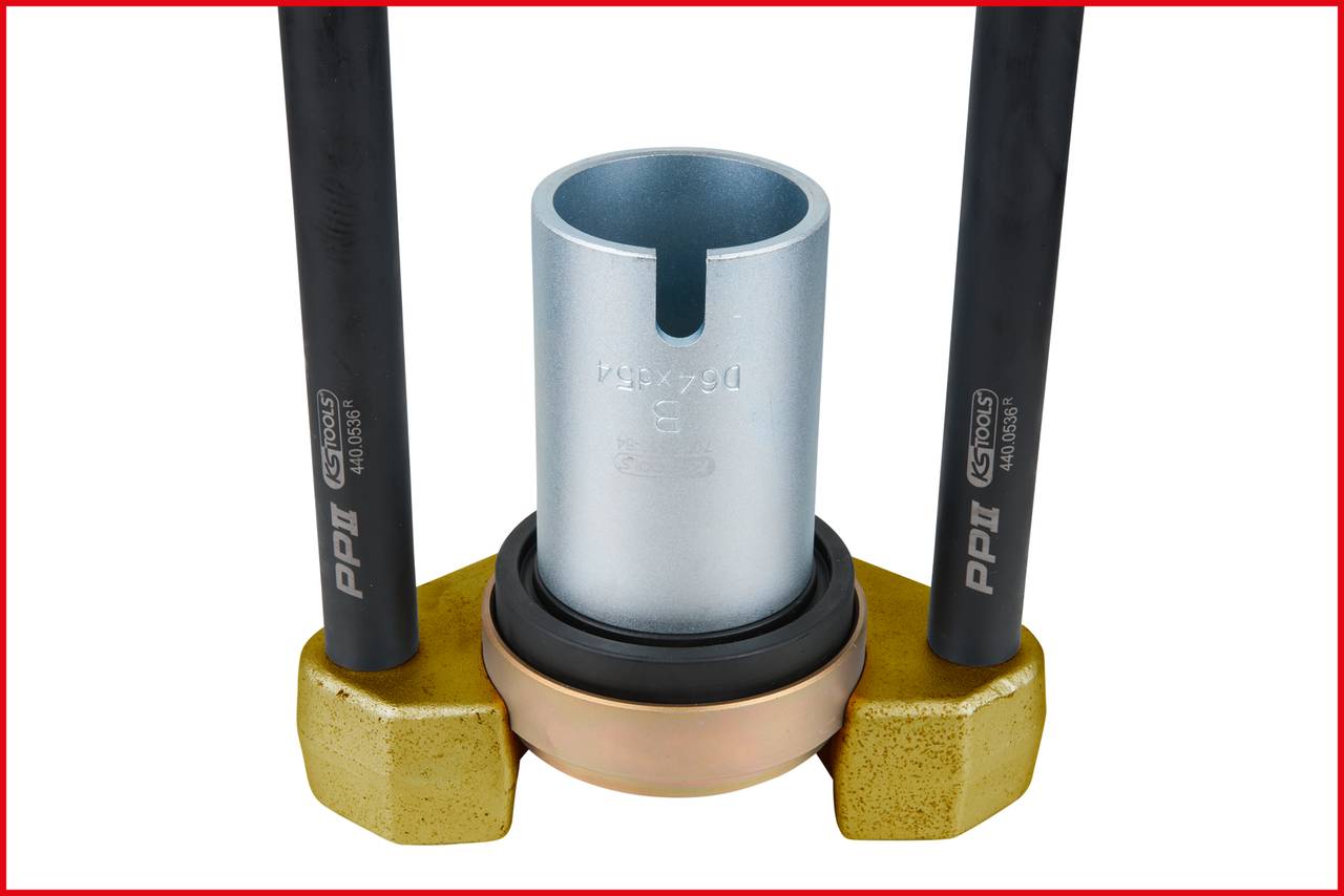 Two parallel black pipes with a circular metal device in the centre, surrounded by a golden base.