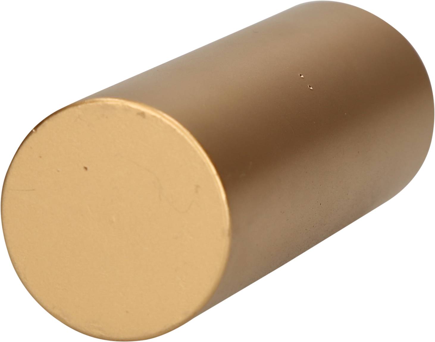 A cylindrical, golden metal object lies horizontally.