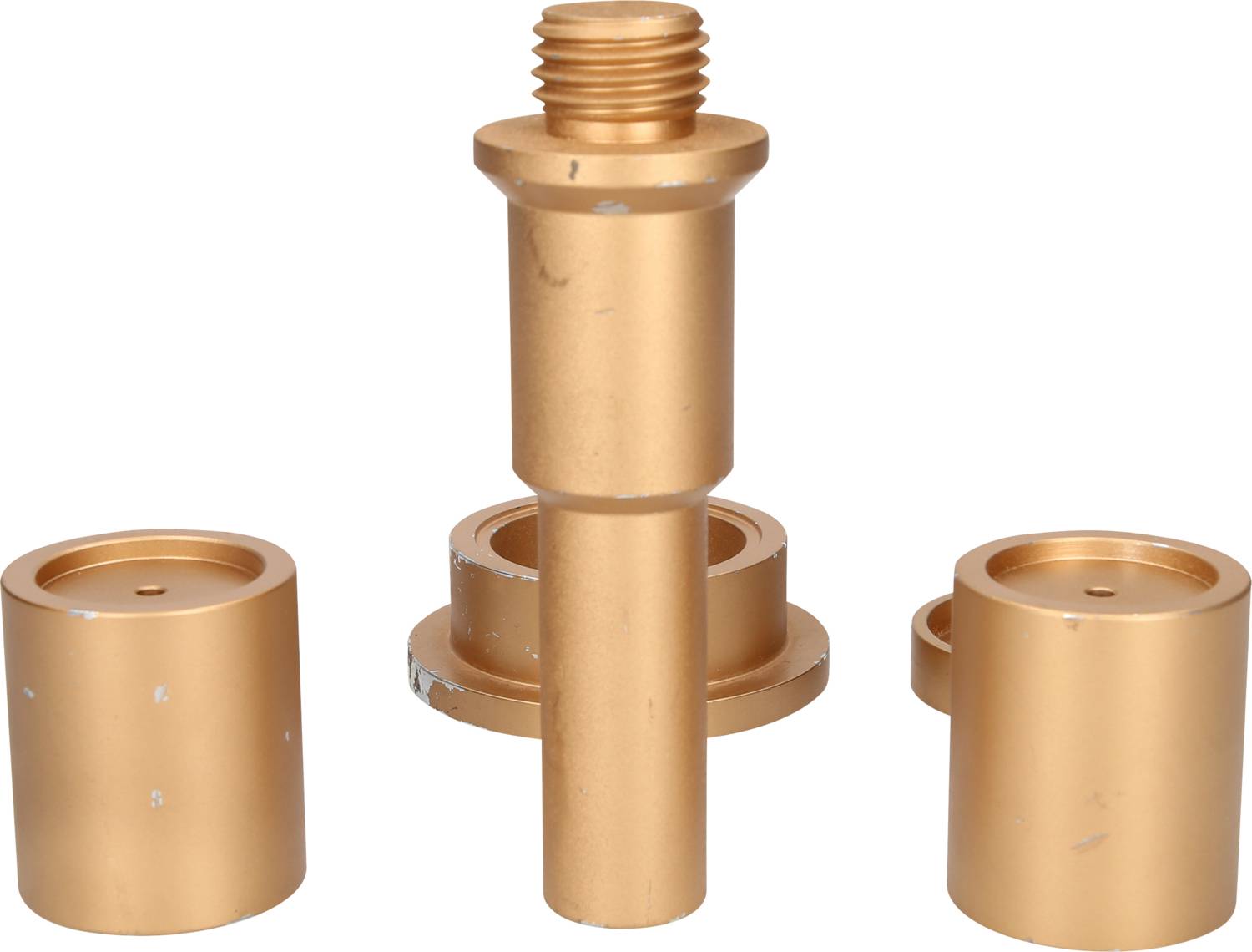Golden cylindrical metal parts, consisting of a longer central piece with thread and two shorter cylindrical pieces.