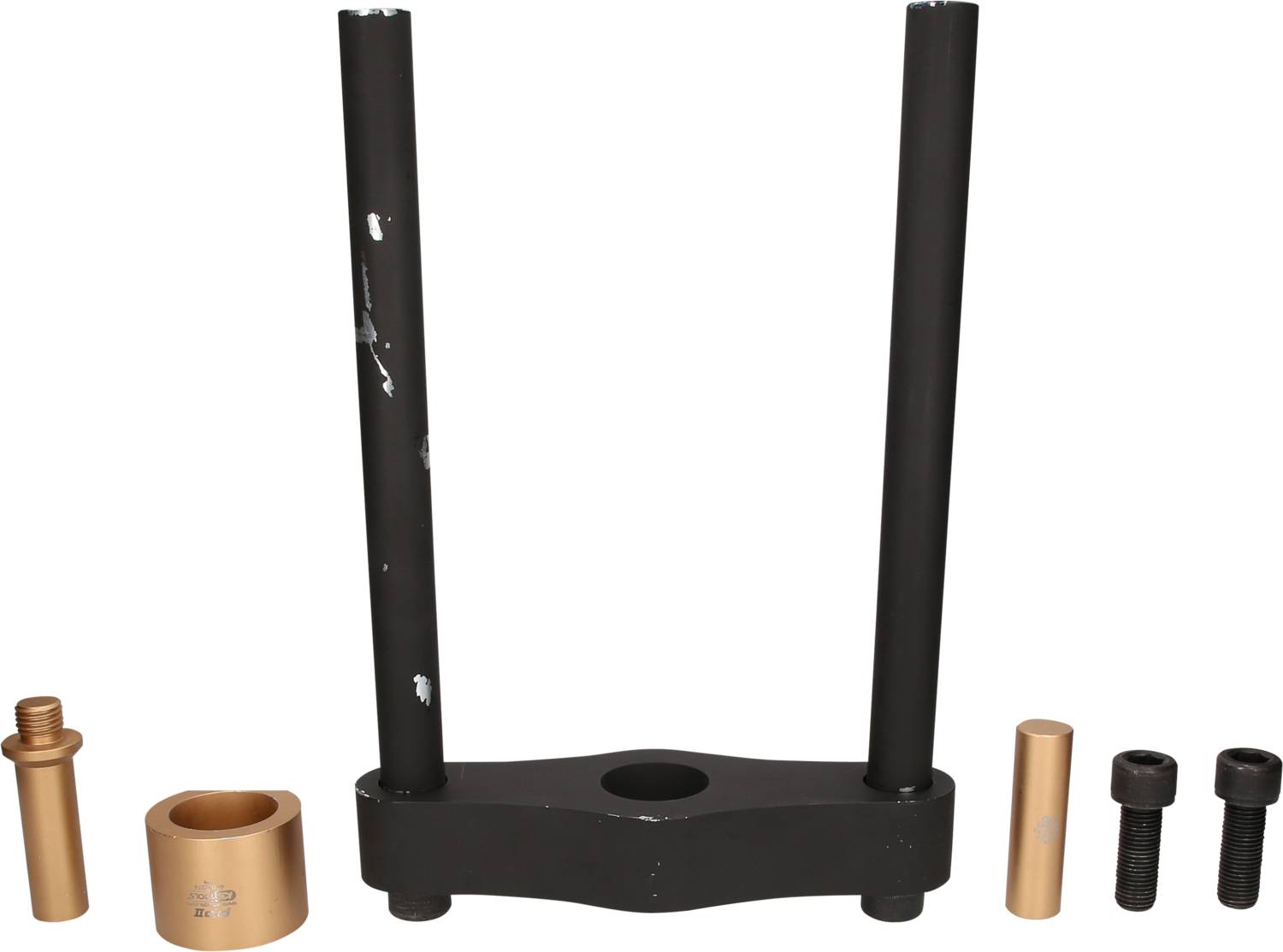 A motor mount tool consisting of a black frame and gold-coloured cylinders, used for assembly in the automotive sector.