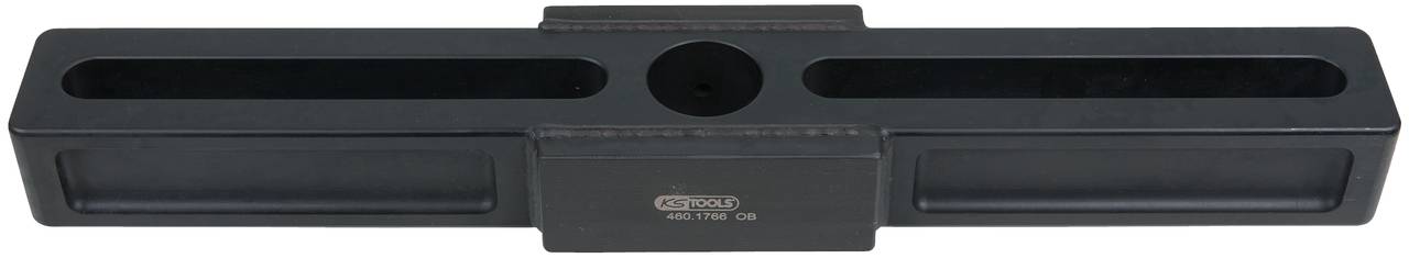 A black, rectangular component with multiple openings and a central round recess, potentially a mounting tool.