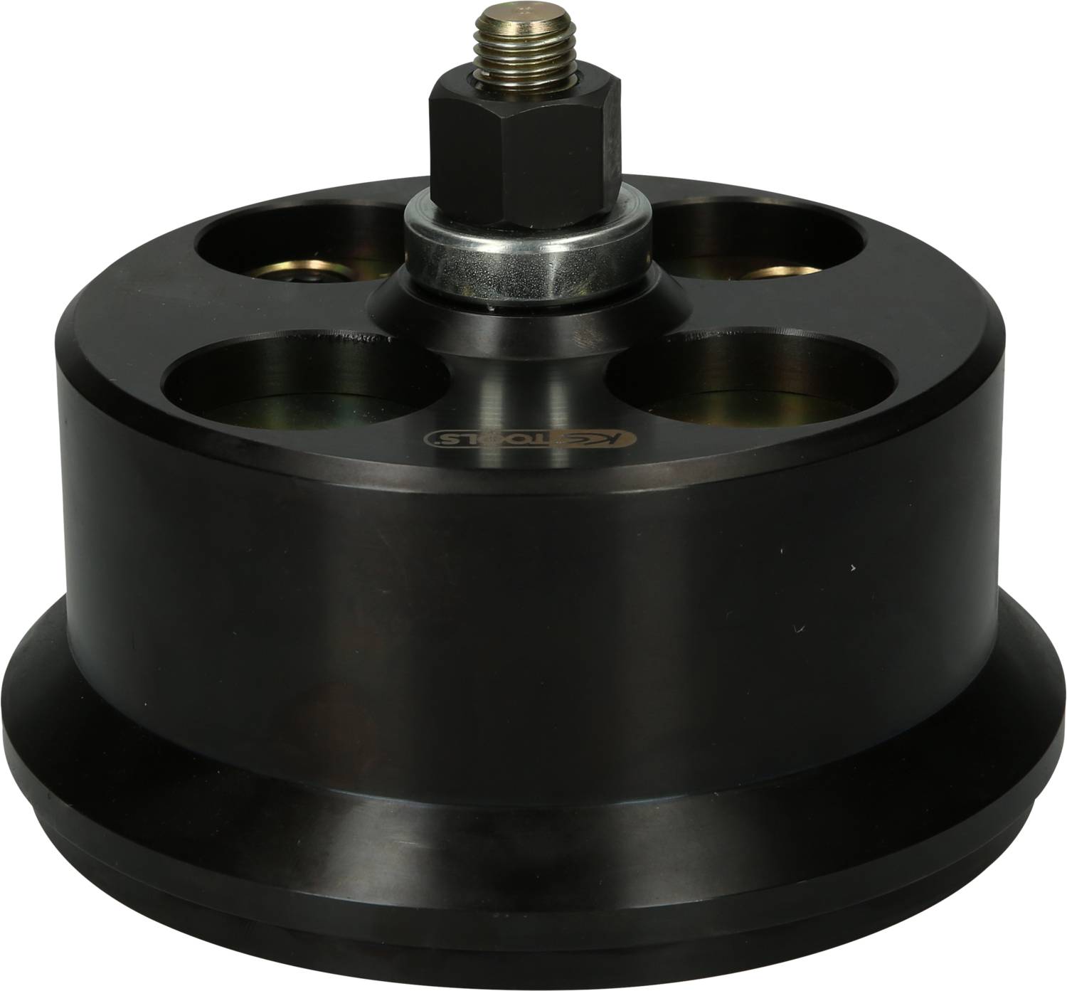 A round, black metal adapter with four holes and a central screw at the top. Used in mechanical applications.