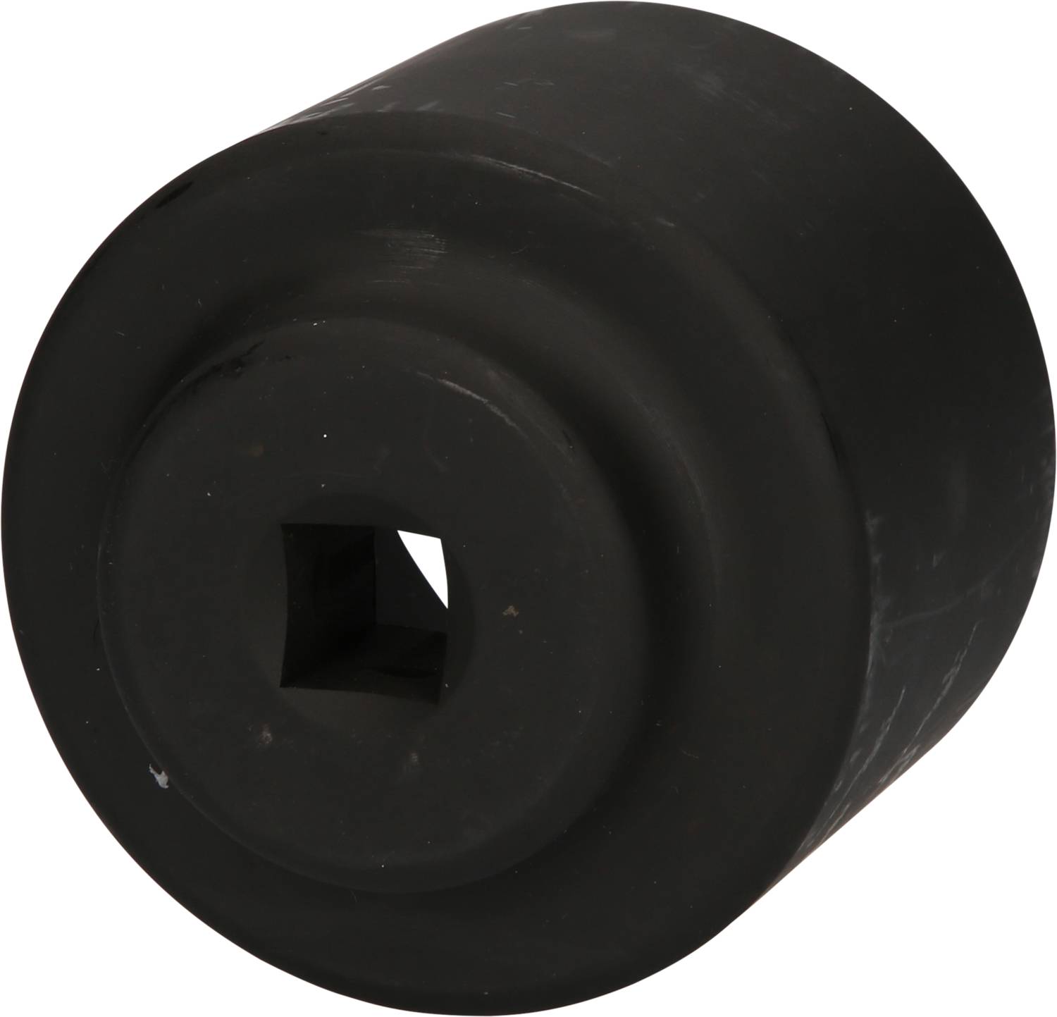 Black, cylindrical spare wheel, square hole in the centre, smooth and uniformly shaped.