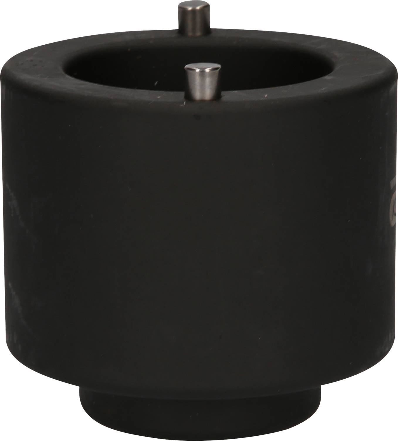 A black, cylindrical object with two small metal pins on the top surface.