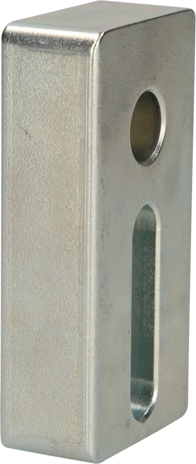 Metal block with two openings; one circular, one oblong. Function or purpose unknown.