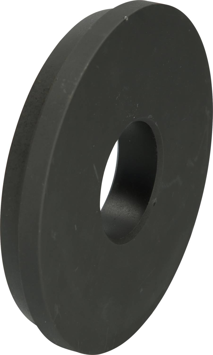 A round, black grinding stone with a hole in the centre, used for sharpening tools.