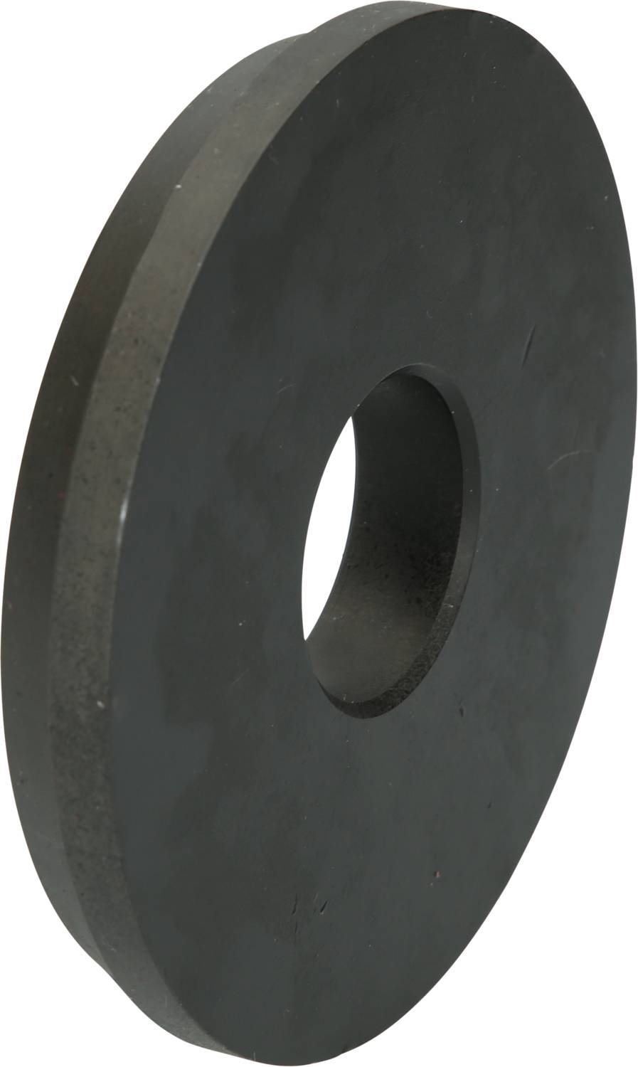 A large, flat, round, black wheel with a hole in the middle, possibly a machine part or a washer.