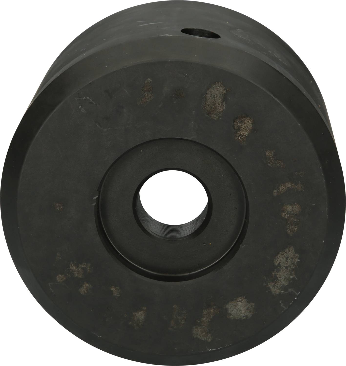 'Central section of a flange coupling made from black steel with a central hole, slightly corroded.'