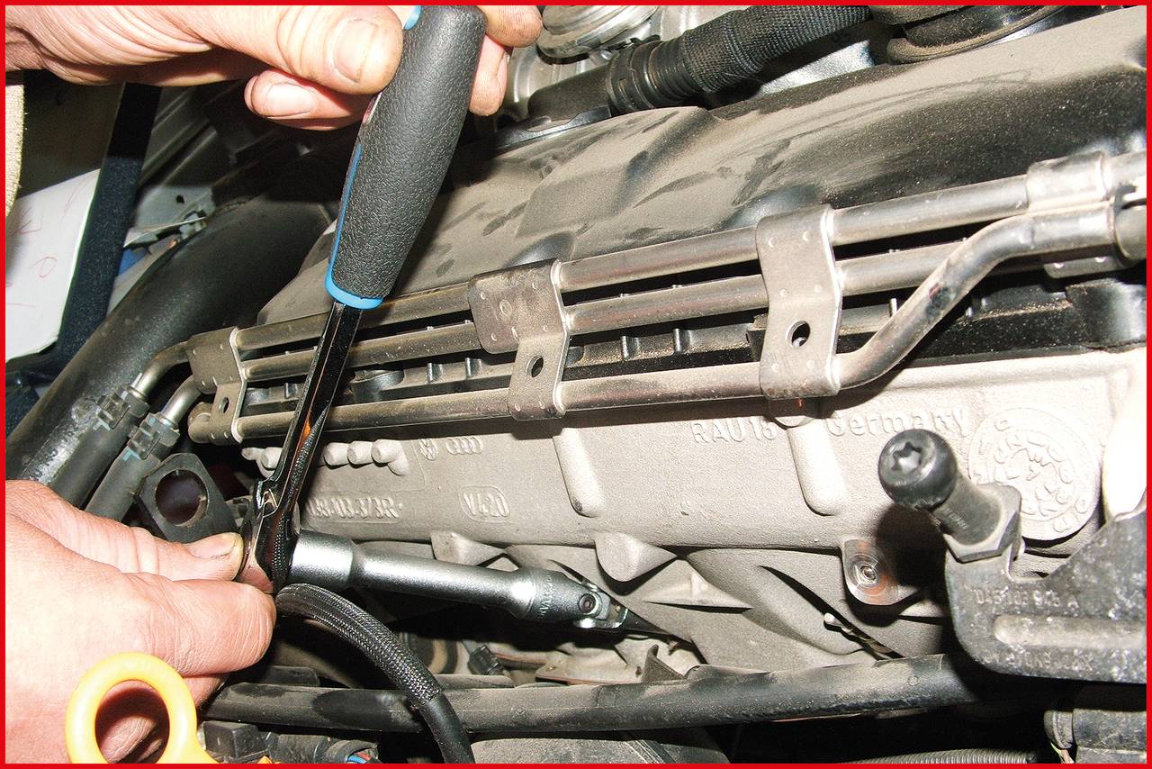 'A person is using a screwdriver on an engine block.'