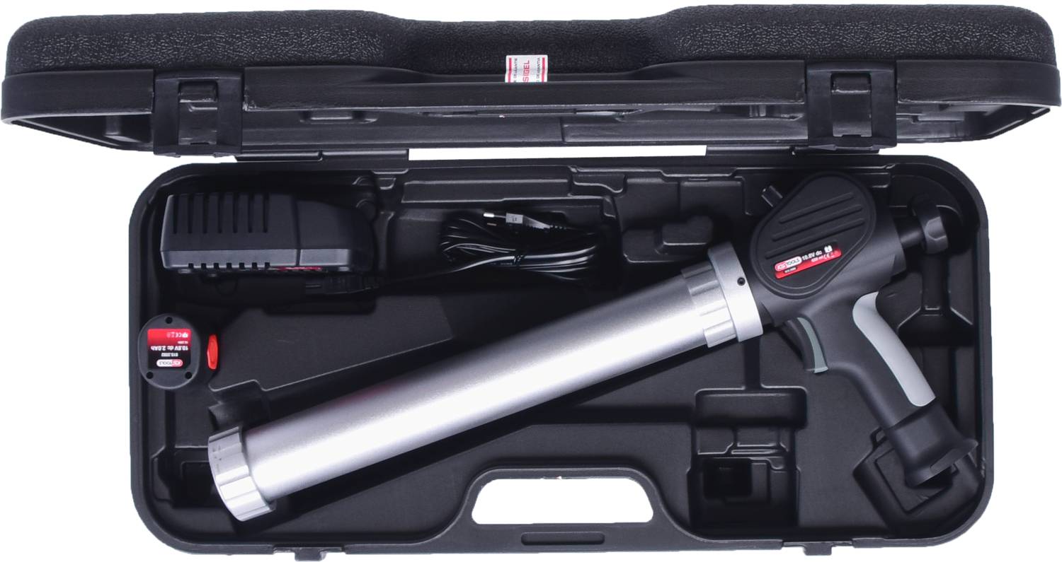 A suitcase containing an electronic tool, charger, and battery. The main tool is elongated and metallic with a handle.