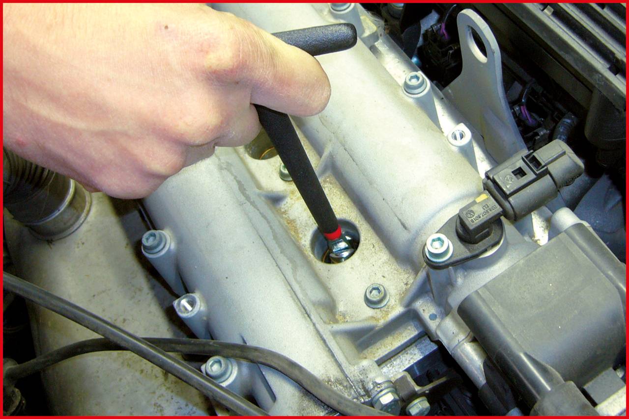 'A hand checks the oil level with a dipstick in the engine compartment of a vehicle.'