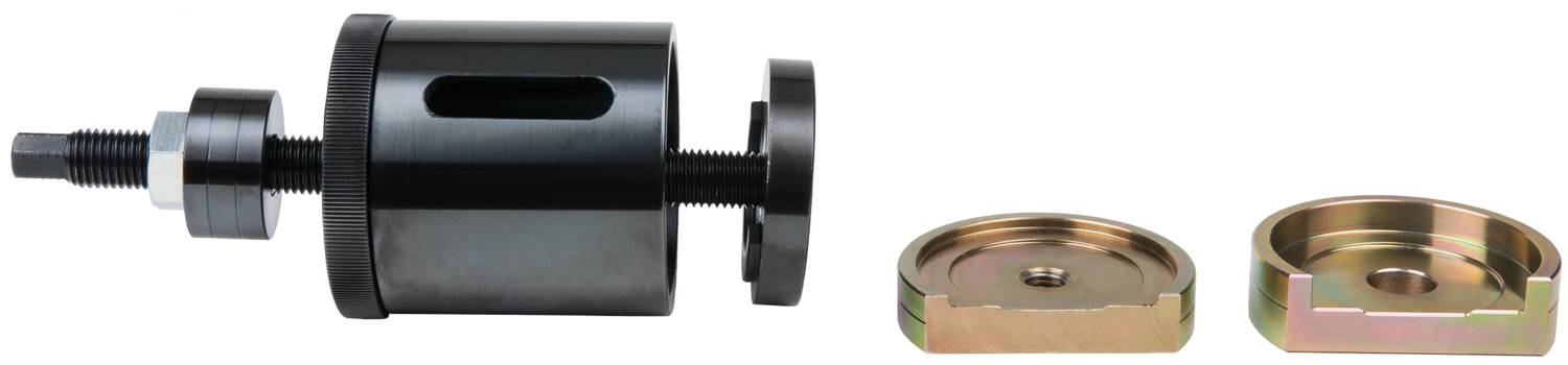 A black tool for car repair next to two metallic discs. Used for assembling or disassembling car parts.