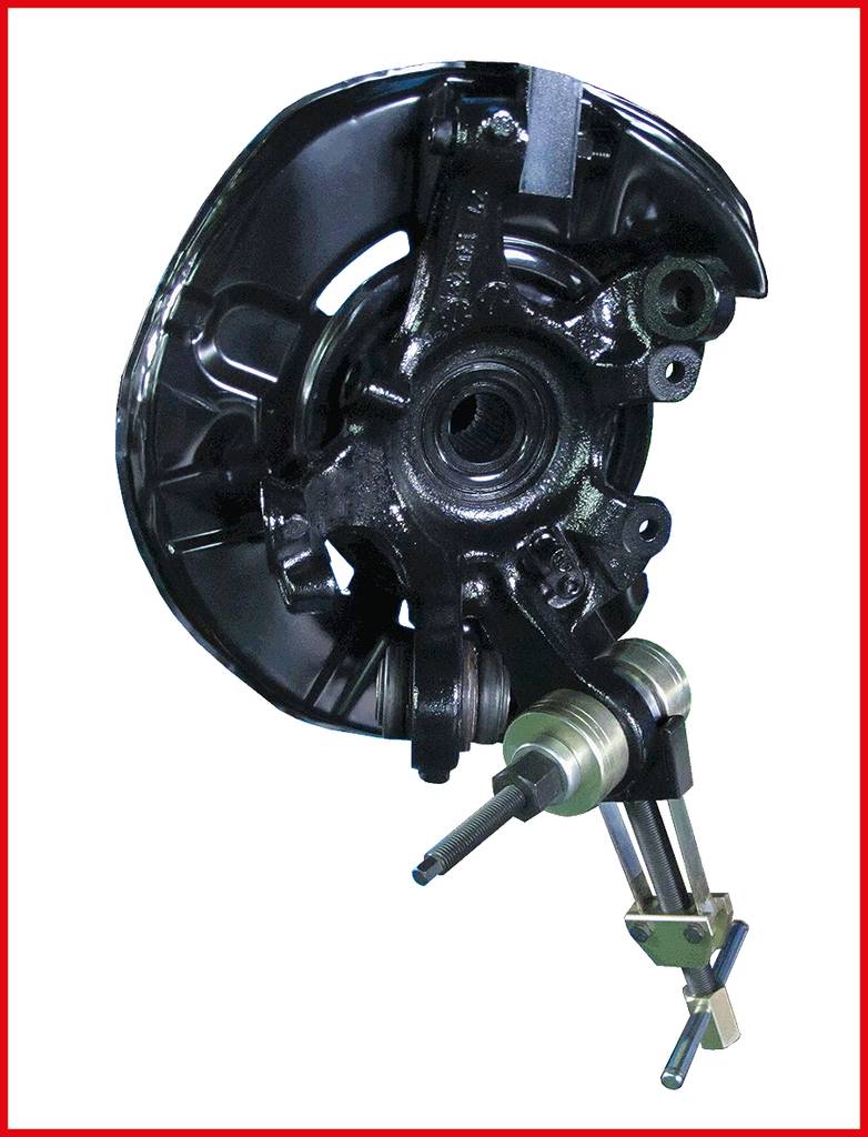 A black automotive component with multiple bolts and connections. It could be part of an engine or suspension system.