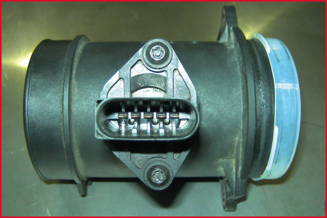 An air mass meter with circular connection points and a central rectangular connection with multiple contacts.