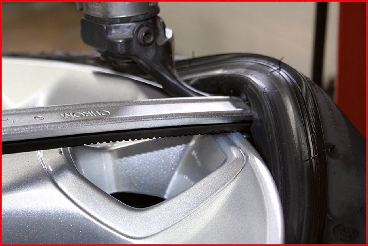 'Tyre Mounting Process: Close-up of a tool positioning the tyre on the rim to ensure a precise fit.'