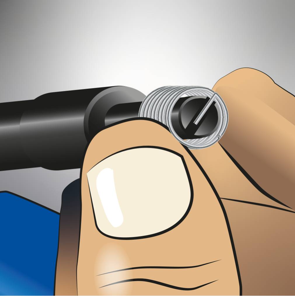 A hand inserts a helical spring into a hole to repair a thread. The spring is positioned with a tool.