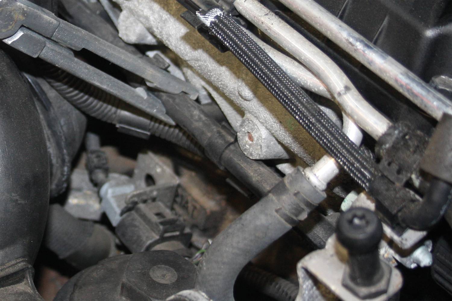 Close-up of a car engine with various hoses and cables.