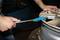 A person is tightening the screws of a car wheel rim with a torque wrench. Hand protection is visible.