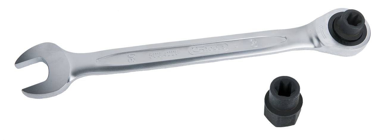 A silver fork ratchet spanner with a black socket insert. Tools are lying on a white surface.