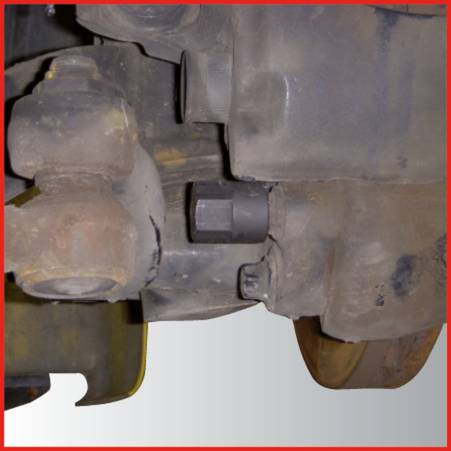 Close-up of a mechanical component with screws and nuts, partially obscured. It shows part of a vehicle.