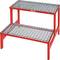 Two-stage red metal step ladder with mesh platforms, suitable for use in workshops or storage areas.