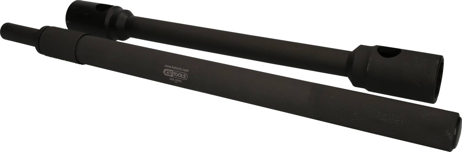 Two black cylindrical metal objects are lying side by side. They are smooth and have larger openings at their ends.