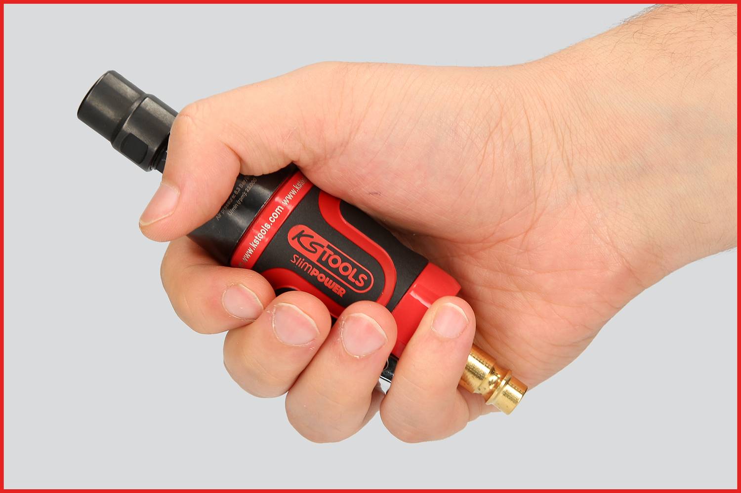 A hand is holding a red and black tool with a metal tip. The tool is branded with the inscription 'KS Tools'.