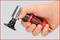 A hand is holding a red pneumatic tool from KS Tools with a round black attachment, ready for use.