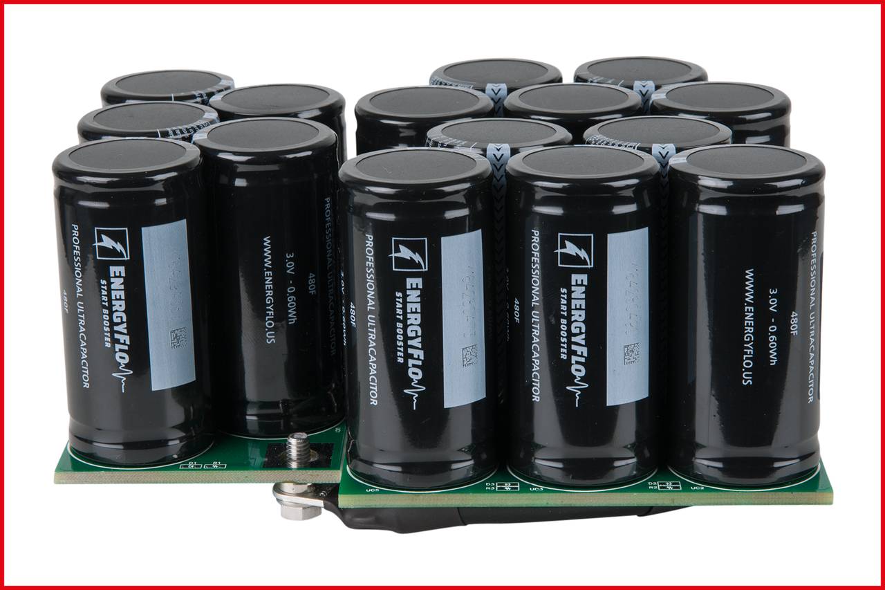 A cluster of black energy storage units on a circuit board. The cylinders are labelled with 'ENERGYCON' and technical specifications.