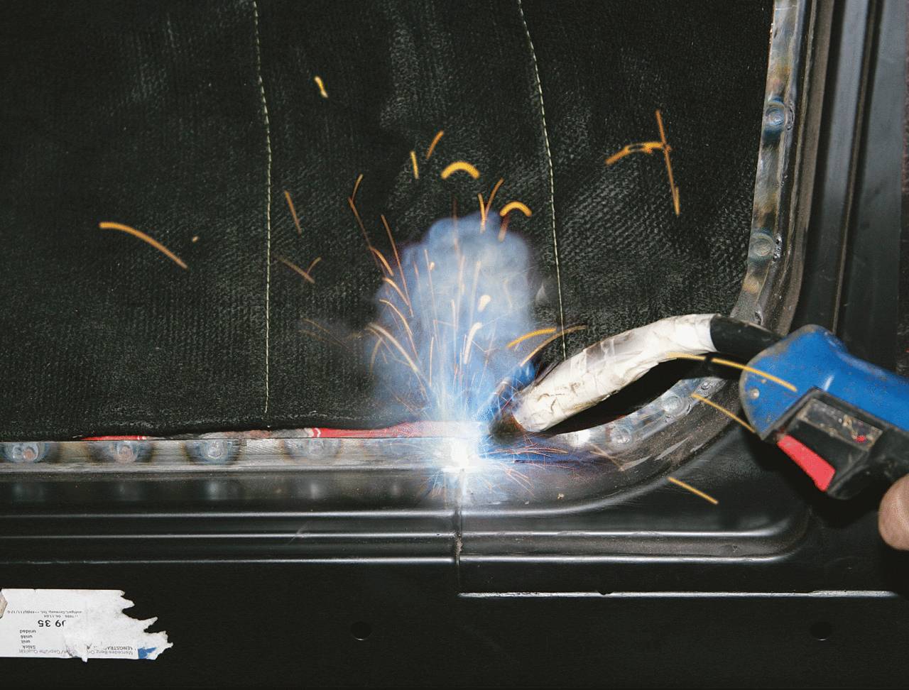 A person is welding metal, sparks flying. Close-up of the welding process using a welding torch.