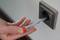 A person is testing a socket with a live voltage tester to check the electrical voltage.