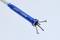 A blue gripping tool with four gripping arms at its tip is shown. It is used for grasping or holding small objects.
