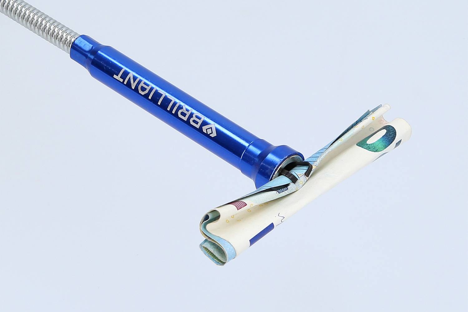 A blue Brilliant electric razor is holding a folded banknote in its blades instead of a razor blade.